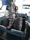 Two major components of the Taxibot make it different from other towbarless tractors: An interface mechanism clamps on the nose landing gear, which is in turn mounted on a “rotating turret.'